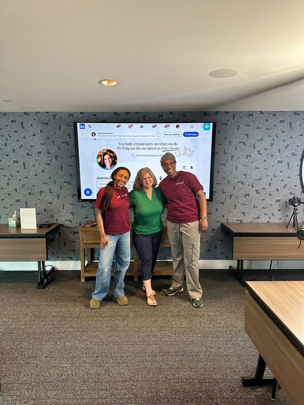 Arena members posing in front of a screen